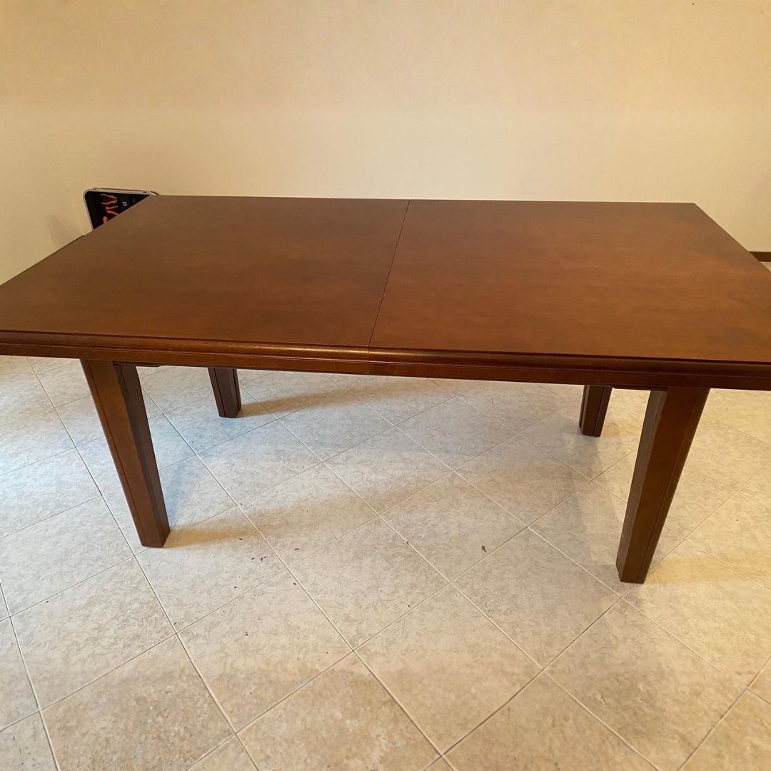 Tavolo fratino rettangolare allungabile in legno color noce scuro, vista frontale su pavimento in ceramica.